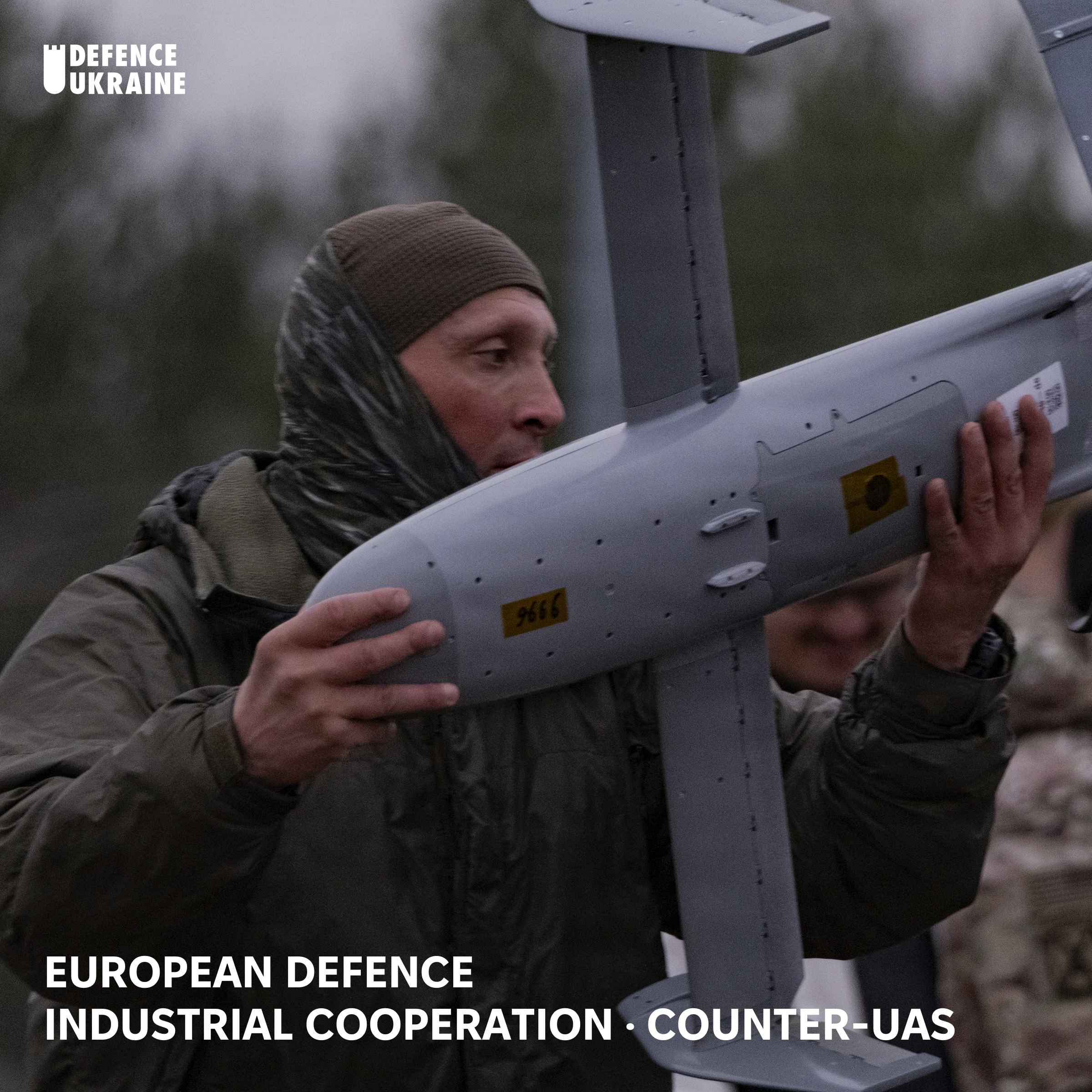A Polish soldier from the 18th Anti-Aircraft Regiment carries a Surveyor interceptor drone from the Merops counter-drone system during NATO eastern-flank training in Poland, illustrating the low-cost effectors Europe now builds from Ukrainian battlefield designs.
